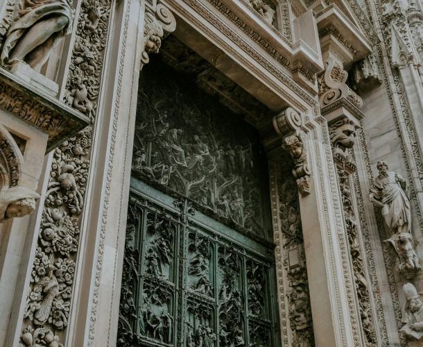 Ornate stone doorway with intricate metal gate and detailed carvings.