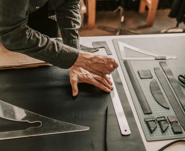 Hands working with architectural drawing tools on a blueprint.