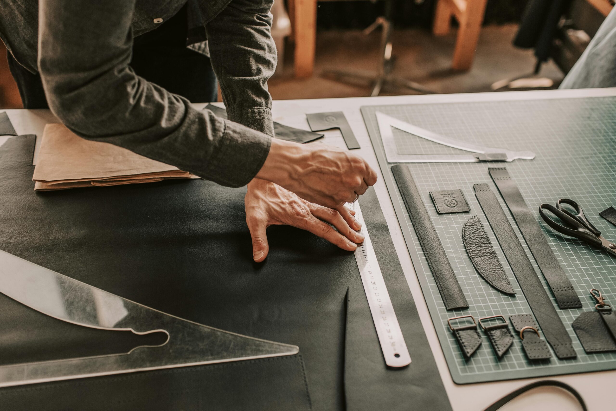 Hands working with architectural drawing tools on a blueprint.