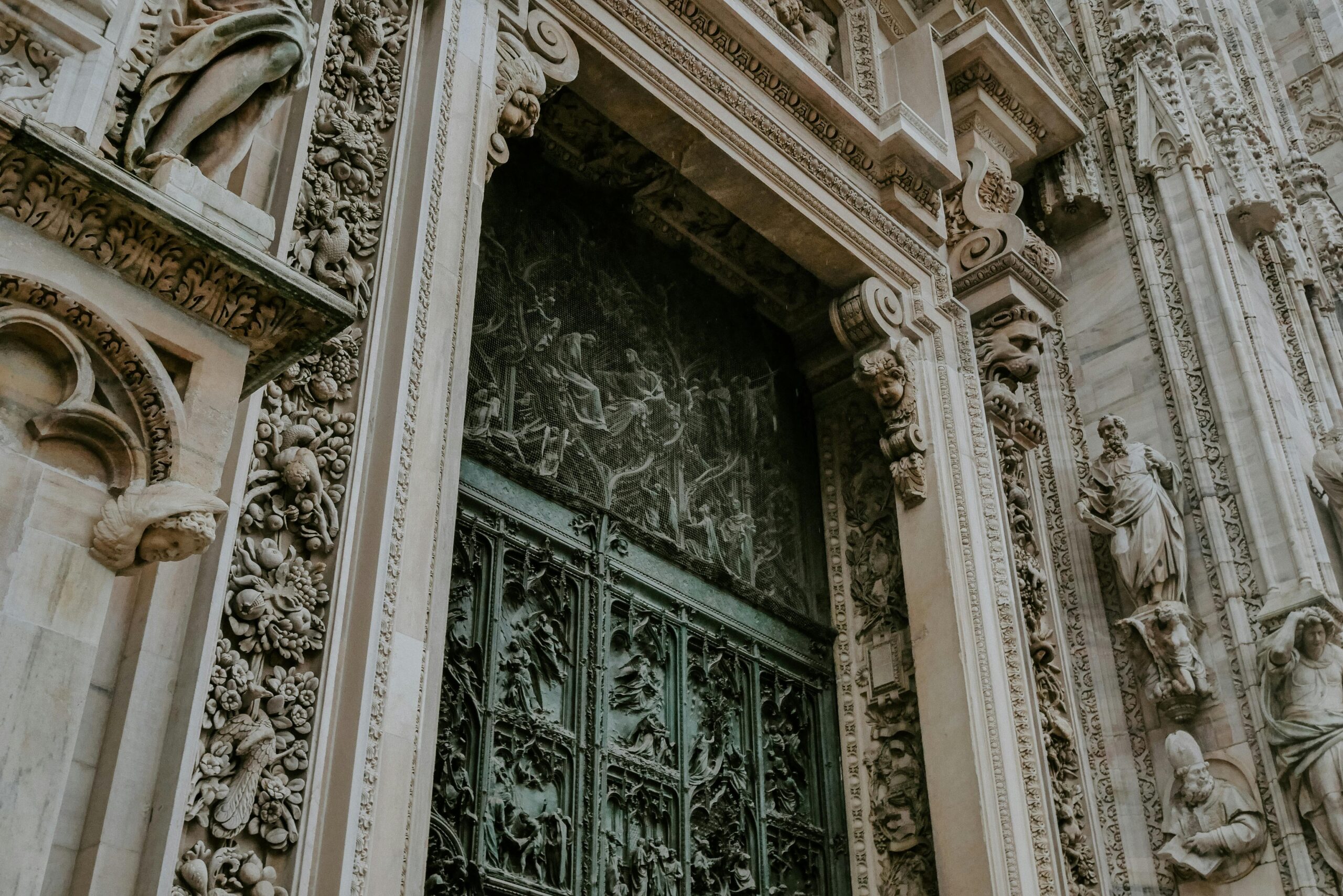 Ornate stone doorway with intricate metal gate and detailed carvings.