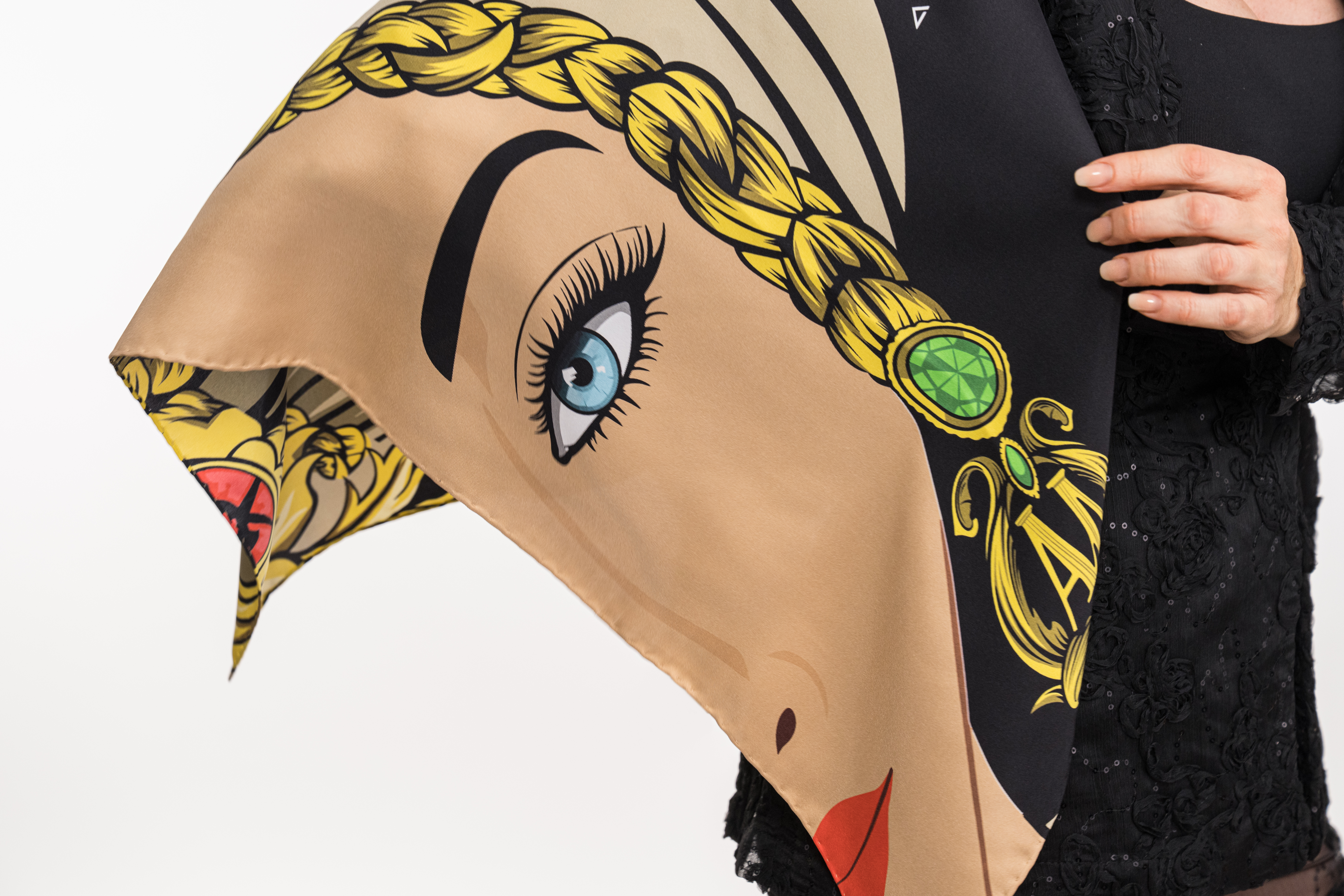 Close-up of a scarf with a stylized female face and braided hair design.