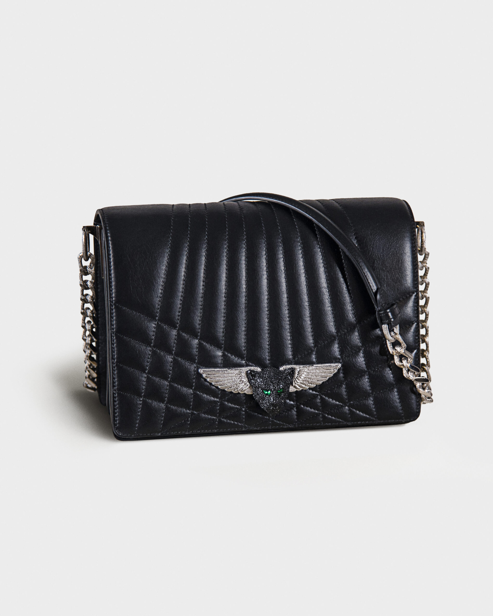 Black quilted leather handbag with silver chain strap and winged emblem.