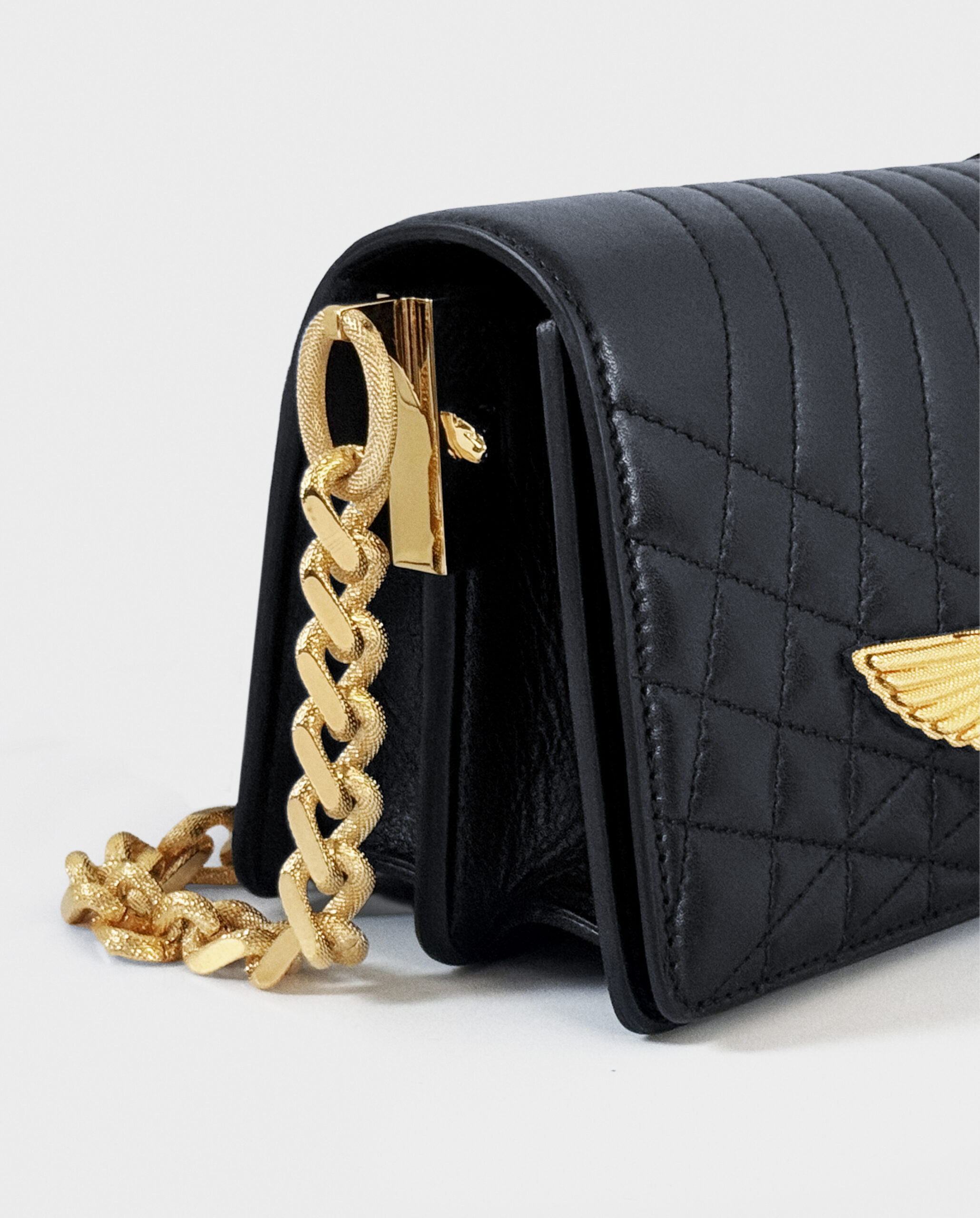 A black leather handbag with crocodile texture and gold chain strap.