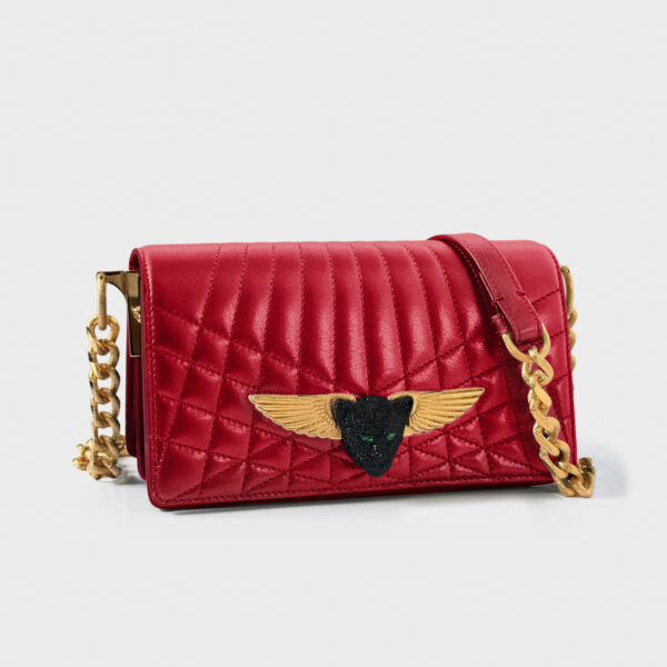 Red quilted leather handbag with gold winged emblem and chain strap.