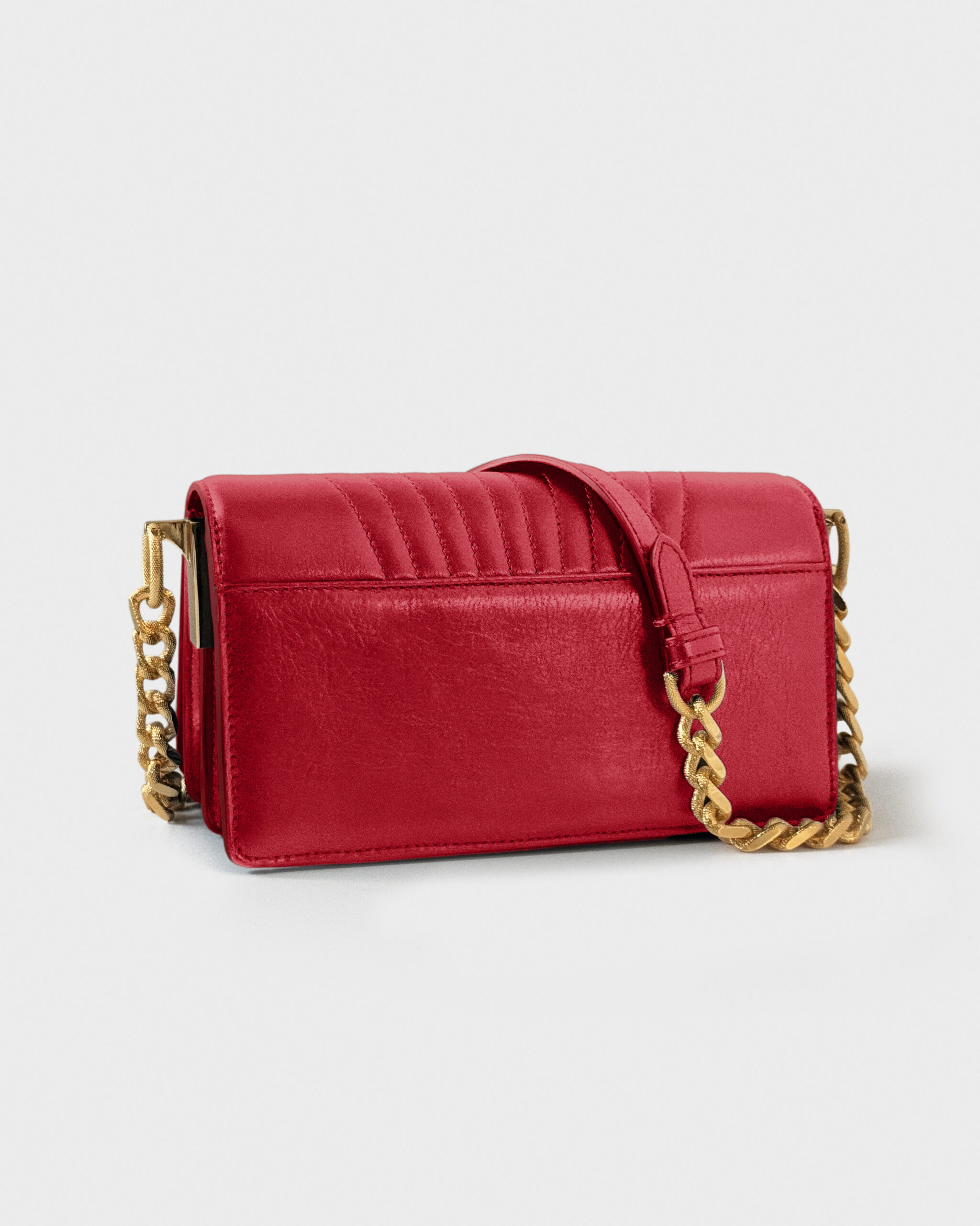 Elegant red handbag with a gold chain strap on a plain background.