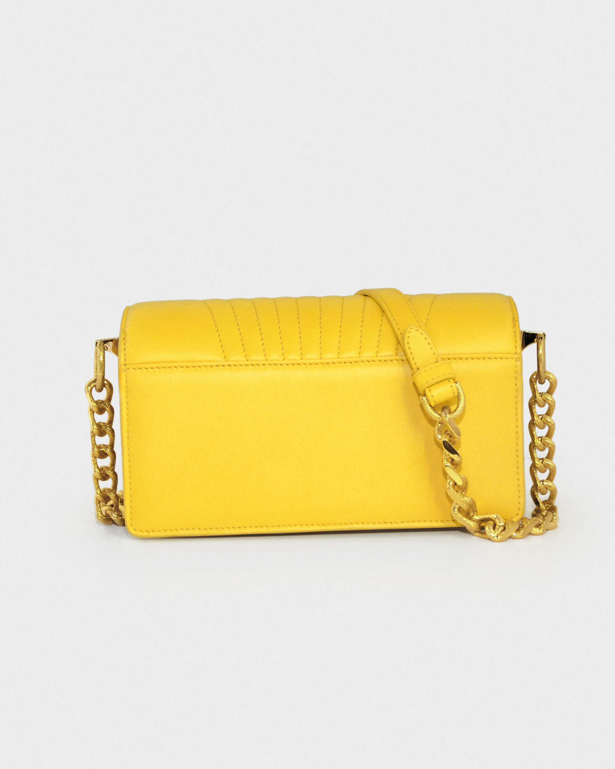 Bright yellow handbag with a chain strap on a neutral background.