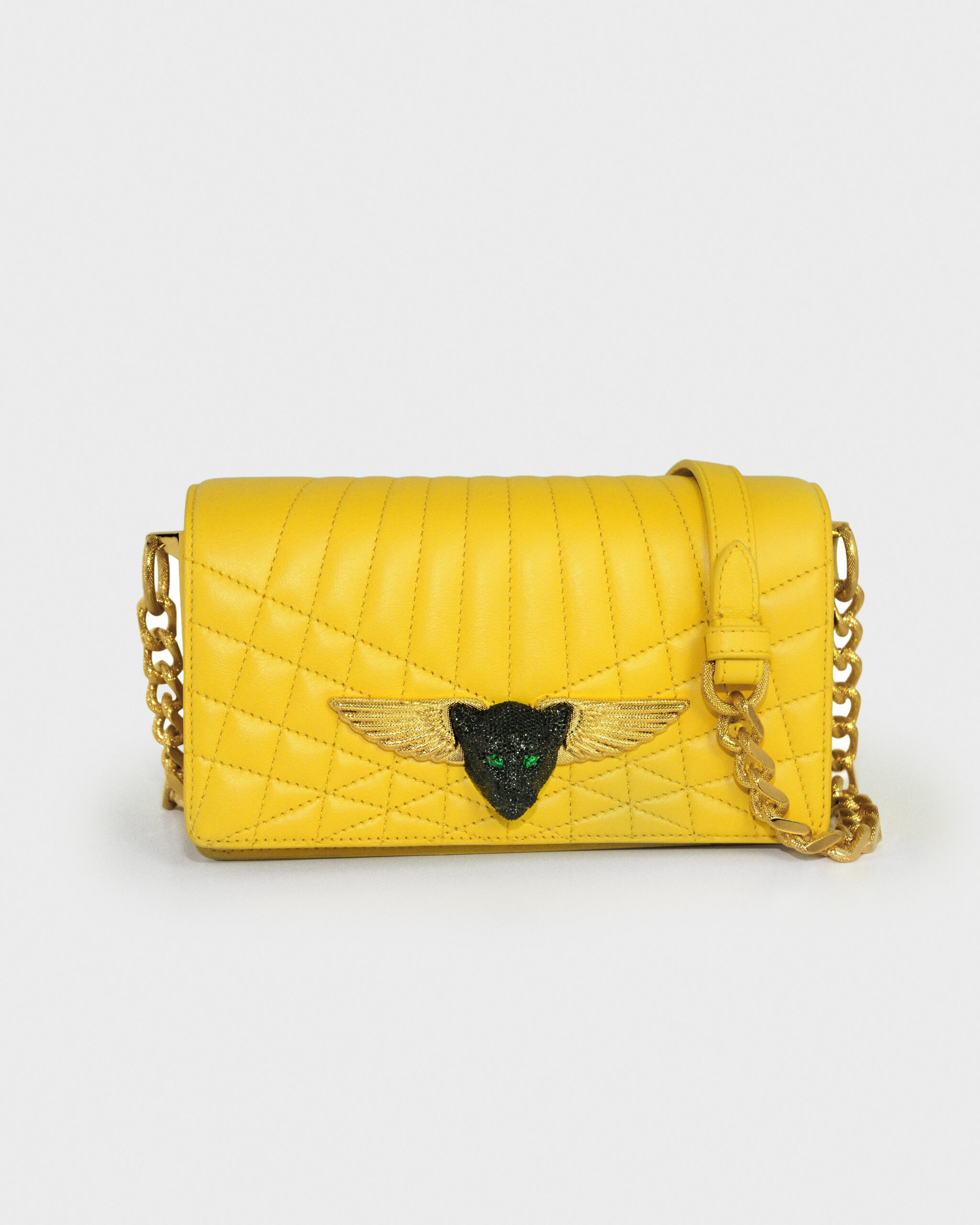 Yellow quilted handbag with winged emblem and chain strap.