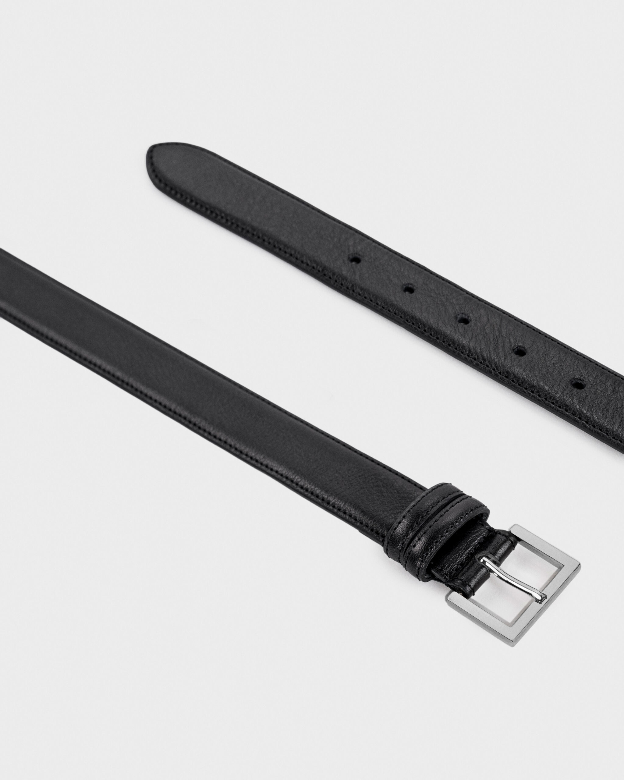 Black leather belt with a silver rectangular buckle.