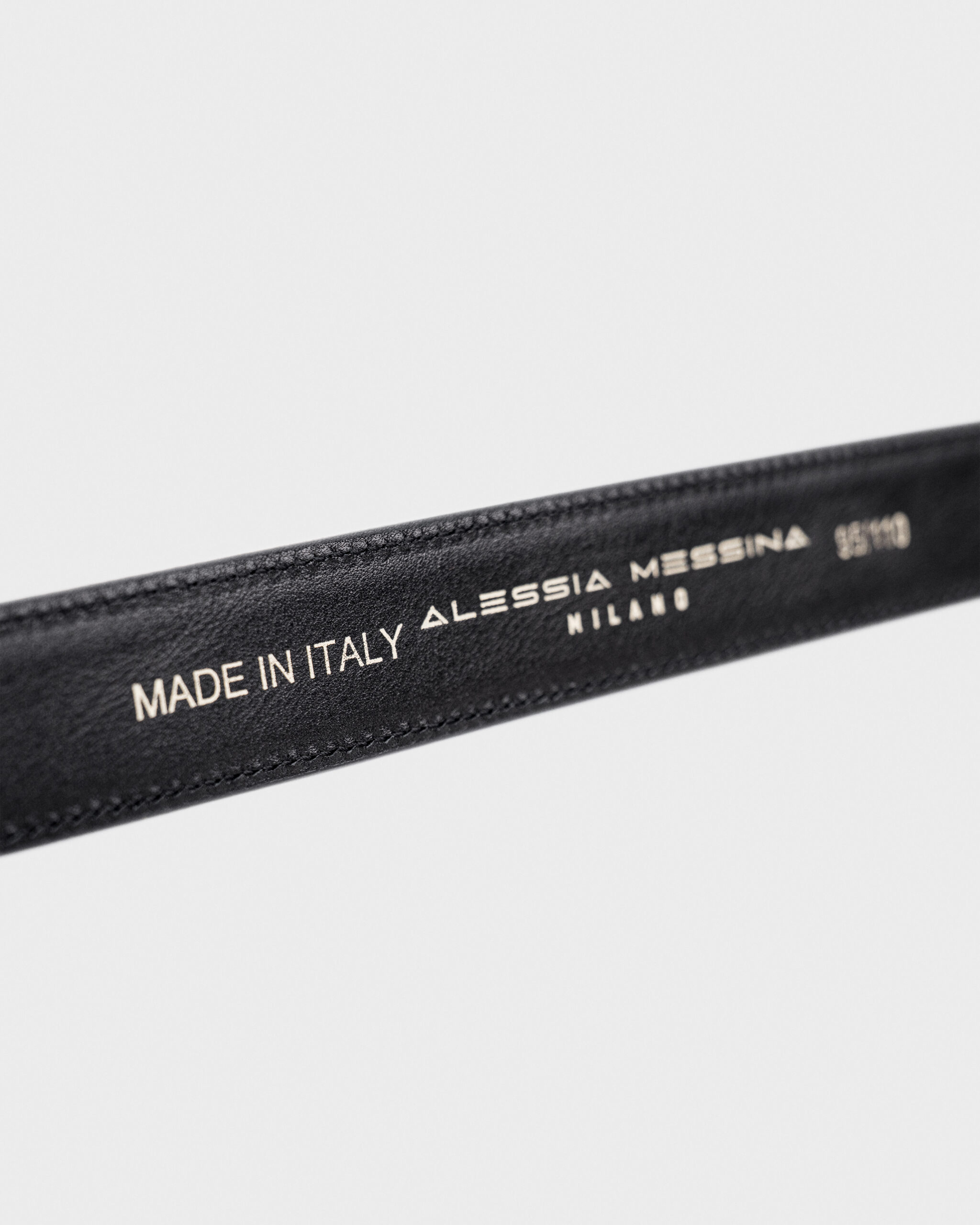 Close-up of a black leather item labeled Made in Italy by Alessia.