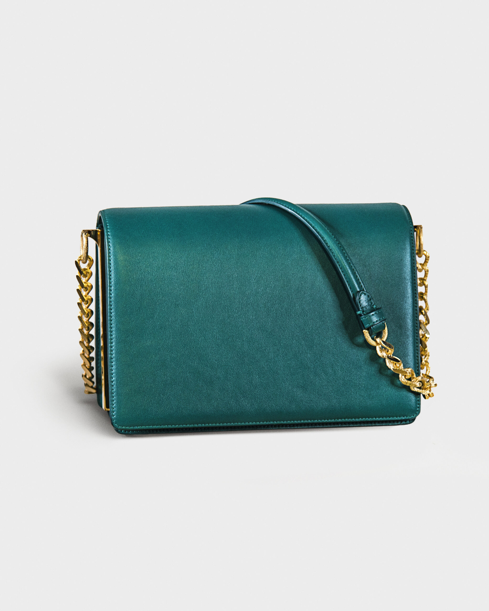 Elegant teal handbag with gold chain strap.