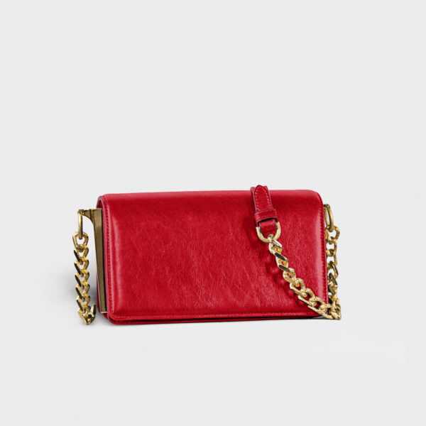 Red leather purse with gold chain strap on white background.