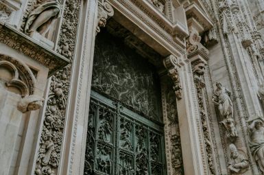 Ornate stone doorway with intricate metal gate and detailed carvings.