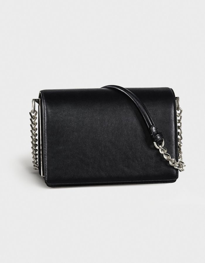 Black leather handbag with silver chain strap on a white background.