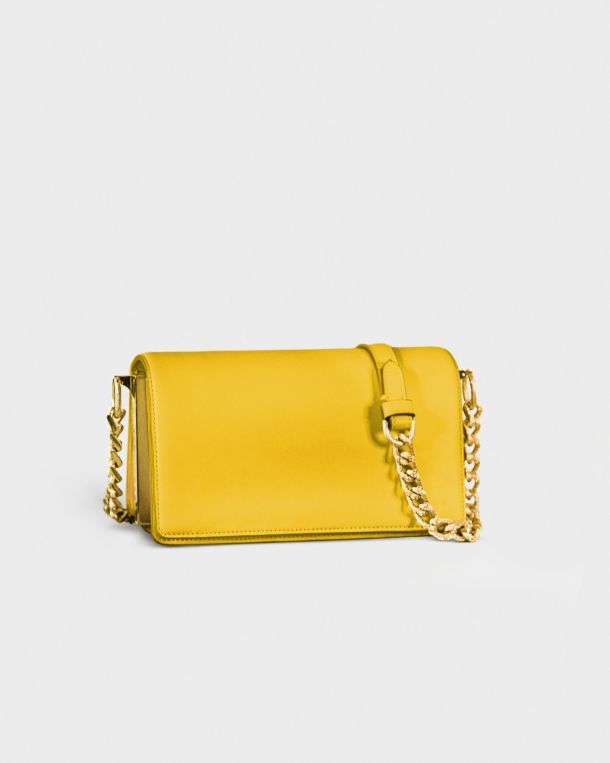 Yellow leather purse with gold chain strap on white background.