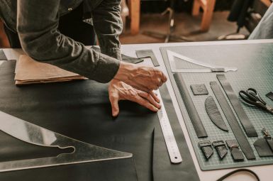 Hands working with architectural drawing tools on a blueprint.