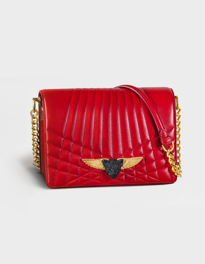 Red quilted leather handbag with gold chain and winged emblem.